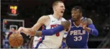  ?? CARLOS OSORIO — THE ASSOCIATED PRESS ?? The 76ers’ Robert Covington (33) reaches for the ball on Detroit’s Henry Ellenson Wednesday in Detroit.