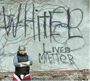  ?? STAFF PHOTO BY PATRICK WHITTEMORE ?? ‘WE’RE NOT GOING ANYWHERE’: Kai Grant, coowner and chief curator of Black Market Dudley, stands in front of graffiti on an exterior wall Wednesday.