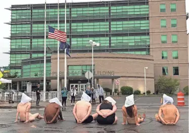  ?? TRACY SCHUHMACHE­R/ROCHESTER DEMOCRAT AND CHRONICLE FILE ?? Protesters in Rochester in 2020 wear “spit hoods,” the mesh fabric bag that Rochester police used on Daniel Prude that year. Prude died of asphyxiati­on as officers restrained him, according to the county medical examiner.