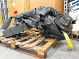  ?? THE ASSOCIATED PRESS ?? A damaged, nearly century-old Confederat­e statue lies on a pallet in a warehouse in Durham, N.C., on Tuesday. Investigat­ors have begun arresting people who allegedly toppled the statue in front of a North Carolina government building, the sheriff said.