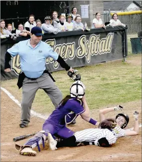  ?? MARK HUMPHREY ENTERPRISE-LEADER ?? The Berryville catcher applies a tag to Prairie Grove senior Sydney Stearman waved in from second by Lady Tiger coach Dave Torres with one out. The brilliant throw home by Lady Bobcats outfielder LoraGrace Hill had a downside for Berryville because it allowed Makinsey Parnell to turn a single into a double. She scored on Kelsey Pickett’s double to end the game with Prairie Grove winning 6-5 after beginning the seventh inning with a 3-run deficit on Tuesday, March 30.