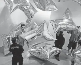  ??  ?? A group of students play with the reflective mylar pillows floating in the “Silver Clouds” installati­on room at the Andy Warhol Museum in Pittsburgh.