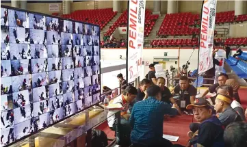  ??  ?? The counting of votes in progress, which is also monitored on television screens.