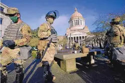  ?? TED WARREN/ASSOCIATED PRESS ?? Members of the Washington National Guard surround the Capitol in Olympia. Many states are gearing up for protests leading up to President-elect Joe Biden’s inaugurati­on Wednesday.