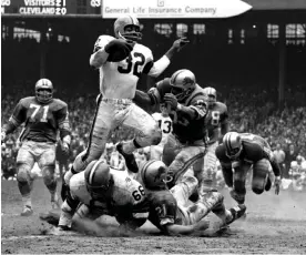  ?? Getty Images ?? Jim Brown, No 32 of the Cleveland Browns, runs through the defence during a 1964 game against the Detroit Lions at Cleveland Municipal Stadium. Photograph: Diamond Images/