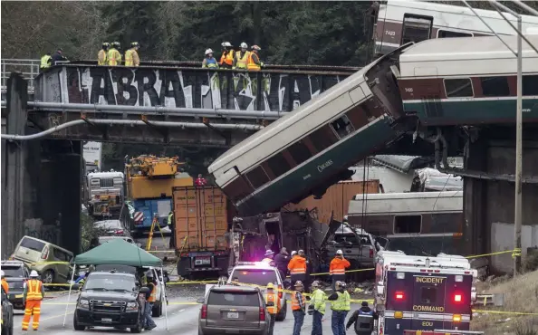  ?? Picture: AFP ?? HORRIFIC ACCIDENT: Emergency crews work at the scene of a Amtrak train derailment at DuPont, Washington state.