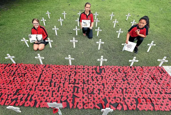  ?? MURRAY WILSON/STUFF ?? Pah¯ıatua School pupils, from left, Keira Fergus, Emma Fergus, and Savali Tinifu, with the crosses the school erected to mark Armistice Day.