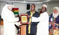  ??  ?? Al-Mutairi Director of Expatriate Lodging Center receives plaque of appreciati­on from Ahmad Abdul Rahman Trawere as Hajia Maryam Wayo looks on.