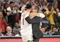  ?? AP Photo/Nick Wass ?? Maryland head coach Mark Turgeon, right, hugs guard Anthony Cowan Jr. (1) after Cowan came out of a game against Michigan on Sunday in College Park, Md.