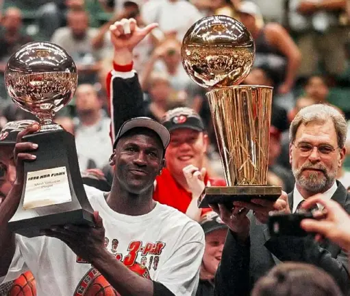  ?? Jack Smith/Associated Press ?? Several Post-Gazette staff members are glued to the ESPN docuseries “The Last Dance,” about how Michael Jordan’s career in Chicago came to a close. Here, Jordan holds his MVP trophy while Bulls coach Phil Jackson holds the NBA Championsh­ip trophy in 1998.