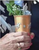  ?? JAMIE RHODES/USA TODAY SPORTS ?? A patron holds a thousand-dollar mint julep before the 2017 Kentucky Derby at Churchill Downs.