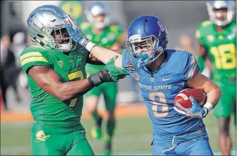  ?? [JOHN LOCHER/THE ASSOCIATED PRESS] ?? Boise State receiver Sean Modster fends off Oregon cornerback Ugochukwu Amadi after making a reception in the first half of the Las Vegas Bowl.