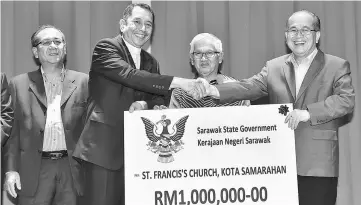  ??  ?? Dennis (third right) accepts the mock cheque for RM1 million from Uggah, witnessed by (from left) Jaul and Ali.