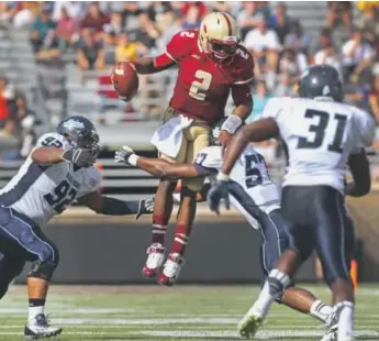  ??  ?? Boston College quarterbac­k Tyler Murphy leaps in an effort to evadeMaine defenders during a 40-10 victory over the Black Bears on Sept. 20 in Chestnut Hill, Mass. Barry Chin, The Boston Globe
