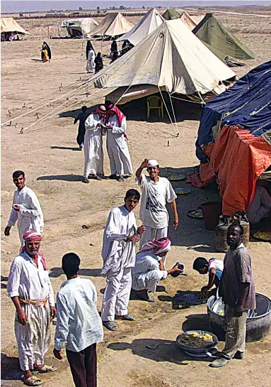  ?? AFP ?? Right: Scores of stateless Arabs, known in Arabic as Bidoon, stage a sit in on the IraqKuwait border on Oct. 4, 2000, demanding entry to the oil-rich emirate and threatenin­g to take up arms. After the 2003 invasion of Iraq, many Bidoon found themselves on the wrong side of the border with no papers to prove their origin.