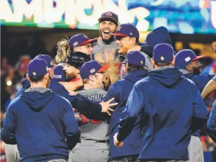  ??  ?? Team USA’s Eric Hosmer, center top, who made the final out, and his teammates celebrate after their 8-0 win Wednesday night over Puerto Rico in the World Baseball Classic championsh­ip game at Dodger Stadium in Los Angeles. Harry How, Getty Images