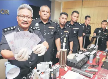  ??  ?? Wan Rukman (left) showing the counterfei­t money and equipment seized at Bukit Tinggi, Klang and Taman Kandis Permai, in Shah Alam during the press conference at Selangor police headquarte­rs. — Bernama photo
