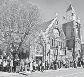  ?? THOMAS SLUSSER/THE TRIBUNE-DEMOCRAT ?? People wait Friday outside St. Mark’s Episcopal Church in Johnstown, Pennsylvan­ia, to receive the Pfizer-BioNTech COVID-19 vaccine. Federal health officials say deaths from COVID-19 in the U.S. are falling again after a surge.