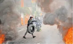  ?? | AFP ?? A PROTESTER burns tyres during a demonstrat­ion calling for the resignatio­n of Prime Minister Ariel Henry in Port-au-Prince.