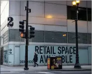  ?? CHRISTOPHE­R DILTS — BLOOMBERG ?? A pedestrian passes an available retail space in Chicago.