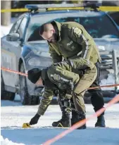  ?? PHOTO AGENCE QMI, MAXIME DELAND ?? Deux policiers de la Sûreté du Québec identifien­t des indices sur la scène.