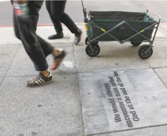  ??  ?? Top: Lizzy Brooks tags a sidewalk in the Tenderloin in San Francisco with a quote from a Temporal Cities archive story. Above: Radka Pulliam (left) and Brooks carry their gear in a wagon. Left: A tag of a quote from a Tenderloin resident.