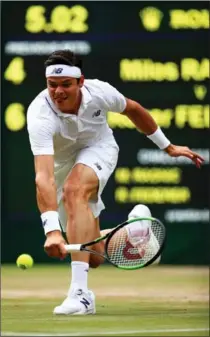  ?? CLIVE BRUNSKILL, GETTY IMAGES ?? Milos Raonic plays a backhand against Roger Federer on Wednesday. Federer won, 6-4, 6-2, 7-6 (4), to advance to the Wimbledon semifinals.