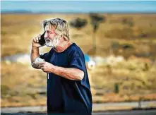  ?? Jim Weber / Associated Press ?? Alec Baldwin talks on the phone Thursday at the Santa Fe County Sheriff ’s Office in Santa Fe, N.M., after he was questioned.