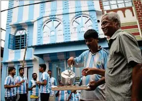  ??  ?? Shib Shankar Patra sert le thé devant sa maison aux couleurs de l’Argentine.