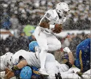  ?? ELSA / GETTY IMAGES ?? Quarterbac­k Ahmad Bradshaw leaps through a pile of players as he helps carry Army to victory in a game that featured just three passes.