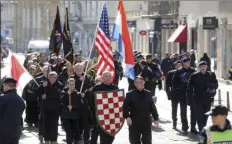  ??  ?? In this photo taken Sunday a group of right-wing radicals wave Croatian and US flags as they march through downtown Zagreb. AP PHOTO