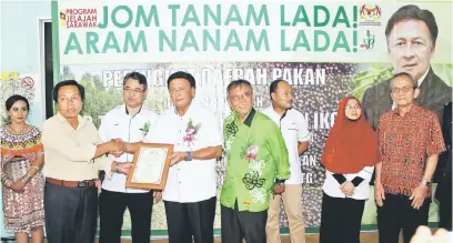  ??  ?? TAHNIAH: Tuai Rumah George Chungut (dua kiri) menerima Anugerah Pekebun Lada Aktif 2016 daripada Mawan.