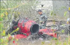  ?? PTI ?? An officer inspects the charred remains of an aircraft after two planes of IAF aerobatic team Surya Kiran crashed near the Yelahanka airbase in Bengaluru on Tuesday.