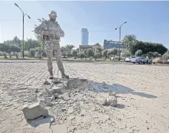  ?? AFP ?? A member of the Iraqi security forces inspects damage outside the Zawraa park after a volley of rockets slammed into the Iraqi capital last year.
