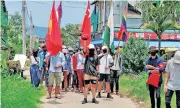  ??  ?? Demonstrat­ors carry flags as they march to protest against the military coup, in Dawei, Myanmar on Sunday