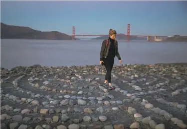  ?? Paul Kuroda / Special to The Chronicle ?? Bryn Bartley walks the labyrinth of rocks created by San Francisco artist Eduardo Aguilera at Lands End. It’s one of the many discoverie­s to be found on safe, socially distanced hikes around the city.