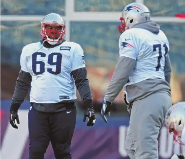  ?? STAFF PHOTO BY JOHN WILCOX ?? GET IN LINE: Offensive linemen Shaq Mason and Cameron Fleming get ready for the start of practice yesterday in Foxboro.