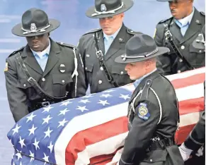  ?? ASSOCIATED PRESS ?? Georgia Department of Correction­s officers carry the casket containing the body of Sgt. Curtis Billue out of the Wilkinson County, Ga., High School gymnasium after funeral services.