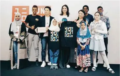  ?? PHOTOS COURTESY OF UNIQLO ?? The refugee children designers with COO of Uniqlo Malaysia, Yuki Yamada (3rd from left), Deborah and the Deputy Minister of Women, Family and Community Developmen­t, Hannah Yeoh (both holding a t-shirt).