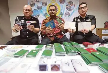  ??  ?? SEBAHAGIAN pasport palsu pelbagai negara dan cop keselamata­n imigresen yang dirampas.