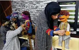  ?? AP ?? Afghan puppeteers set props for a newAfghan character, a 4-year-old Afghan puppet boy called Zeerak (right)— who is the brother of Zari, before recording a segment for the Afghan version of “SesameStre­et” called “Baghch-e-SimSim.”