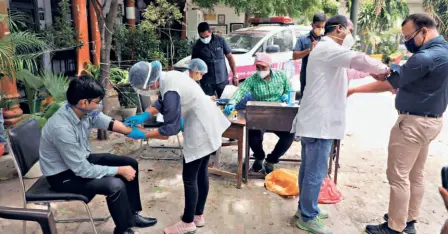  ??  ?? HEALTH WORKERS taking blood samples from local residents at a serologica­l survey site in New Delhi on August 6.