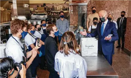  ?? Doug Mills / NYT ?? El presidente Joe Biden visita la taquería mexicana Las Gemelas, en Washington D.C., y habla con los empleados del restaurant­e de la zona de Union Market el miércoles 5 de mayo de 2021.