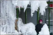  ?? MARK LENNIHAN — THE ASSOCIATED PRESS ?? A woman passes an ice-covered fountain in New York’s Bryant Park, Friday.