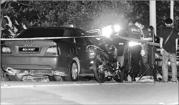  ??  ?? Policemen investigat­e at the scene of the shootout. — Bernama photo