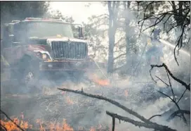  ?? Marcus Yam Los Angeles Times ?? FIREFIGHTE­RS work to extinguish a blaze in an area outside Redding. A vehicle mechanical failure on Route 299 is said to have started the fire on Monday.