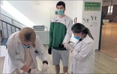  ??  ?? Darío Brizuela (Unicaja) recibe un pinchazo en el dedo para hacerle la prueba serológica del coronaviru­s.