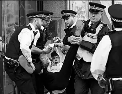  ??  ?? Police officers detain an activist during Extinction Rebellion climate change protest in front of Brazilian Embassy in London, Britain, August 13, 2019.