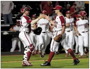  ?? NWA Democrat-Gazette/J.T. WAMPLER ?? Catcher Grant Koch (left) congratula­tes Arkansas reliever Jake Reindl after the final out Tuesday night. Reindl struck out the side in the ninth inning to earn the save.