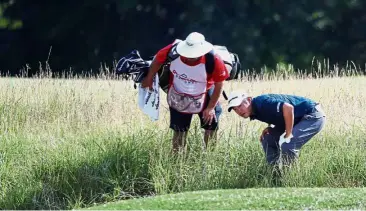  ?? AFP ?? Where is it?: John Huh of the United States trying to locate his ball on the seventh hole with the help of his caddie during the first round of the Quicken Loans National in Potomac on Thursday. Right: David Lingmerth of Sweden watching his shot from...